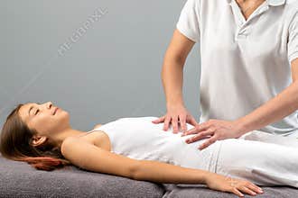 Therapist doing abdomen massage on little girl.