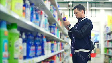 A stylishly dressed man chooses a detergent for the bathroom