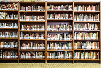 Library with book shelves full of book arranged in order on regals