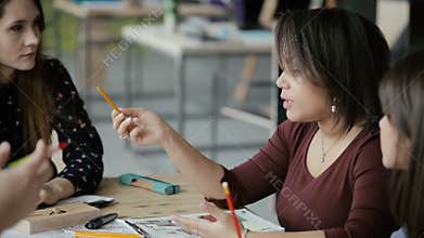 Mixed race group of people on business meeting in modern office. Female team leader giving direction, discussing ideas.