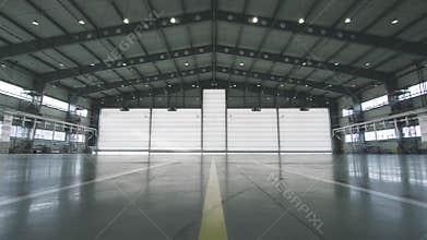Roller shutter door and concrete floor inside factory building for industrial background. Airplane in front of half