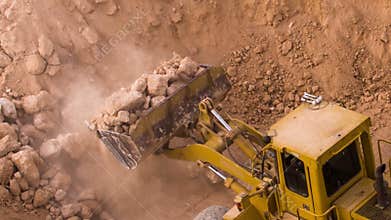 Top view excavator loading crushed rock on dumper truck