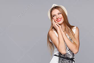 Happy young joyful woman looking sideways in excitement. Isolated over gray