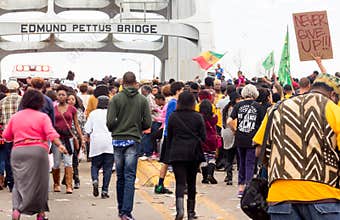Crowd of mostly African-American people peacefully march accross Edmund Pettus Bridge