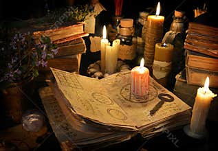 Bloody candle on witch book in candle light