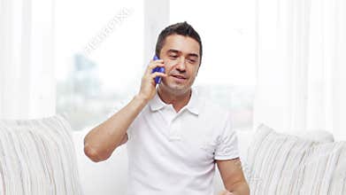Happy man calling on smartphone at home