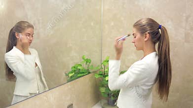 Beautiful woman applying make up