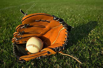 Baseball glove with baseball on the field