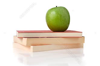 Apple over books pile