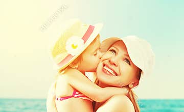 Happy family on beach. baby daughter kissing mother