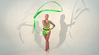 Beautiful acrobat dancing with a sash in slow motion