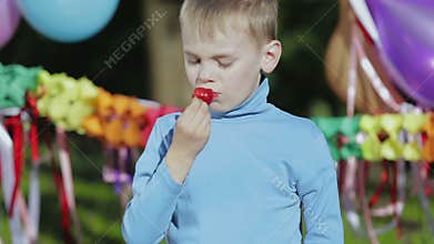 Boy enjoys strawberry.