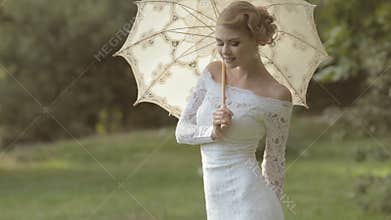 Gentle bride with an umbrella on the nature