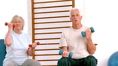 Active seniors lifting hand weights