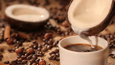 Pouring coconut milk into a cup with coffee
