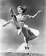 Woman in a flowing dress leaping through the air