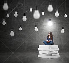Woman sitting on a pile of books thinking about problem