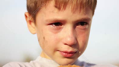 Dirty orphan boy close-up crying and looking at
