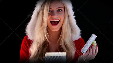 girl in santa costume opening a gift
