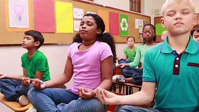 Pupils doing yoga in classroom
