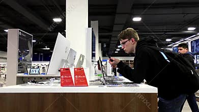People trying new computer inside Best buy store