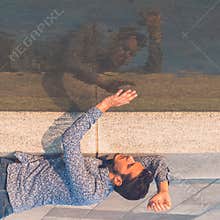 Young handsome man looking at himself in the water