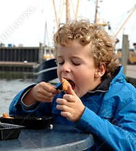 Boy eating Fish in Harbour