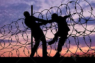 Silhouette of refugees and barbed wire