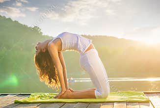 Woman doing yoga on the lake - relaxing in nature