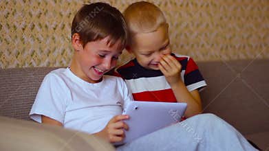 Two boys play on a white plate sitting on the