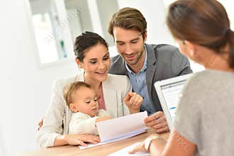 Young family in real-estate agency buying new house