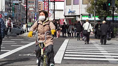 View of traffic and people moving through the city busy streets with view of shops along the side