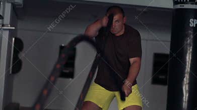 Boxer doing exercise in the gym. Look through the net. Slow motion