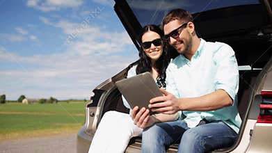 Happy couple with tablet pc at hatchback car trunk 21