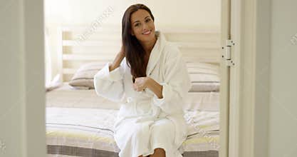 Happy friendly young woman in a white bath robe