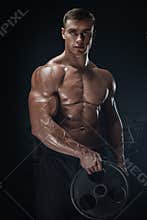 Muscular man workout with barbell plate