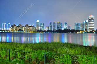 Greenery by Kallang River, with skyline and colourful reflections in the background