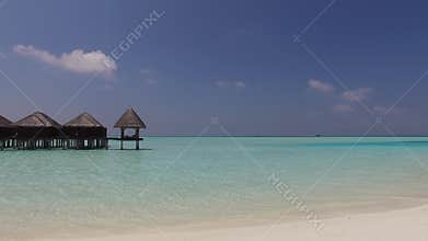 Bungalow huts in sea on tropical resort beach