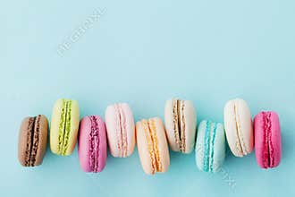 Cake macaron or macaroon on turquoise background from above, colorful almond cookies, top view