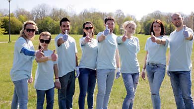 Group of volunteers showing thumbs up in park