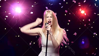Girl singing and dancing with retro microphone strobe lighting effect.