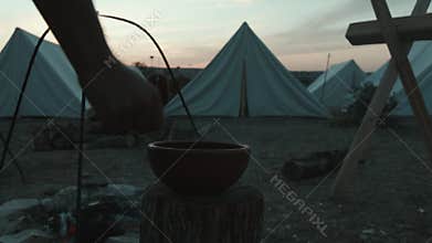 Roman legionary scoops water from a jug in the military camp