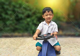 Happy little boy drive toy car.Playful kid at playground