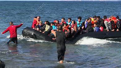 LESVOS, GREECE - NOV 2, 2015: Refugees in a rubber dinghy swim to shore from Turkey.