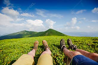 Couple in hiking boots having fun and enjoying wonderful breathtaking mountain view