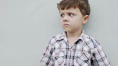 Little boy sitting near the house