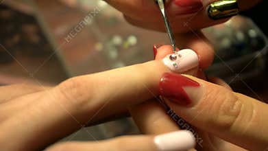 Manicurist makes nail art decoration girl