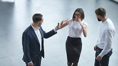 Top view of young male consultant and buyers signing contract for new car in auto show. Concept for car rental