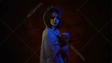 Ghost of a dead bride in white dress and wedding veil is appearing in the picture. Image of a young woman with skull