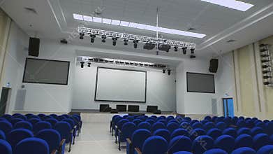 Spacious, modern conference room with plenty of seating place, equipment projector for presentations. Camera moves down